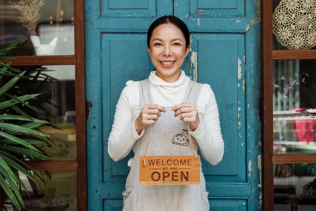 A woman holding an "open" sign.