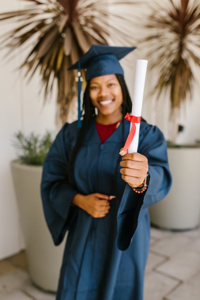 A graduate holding their diploma.