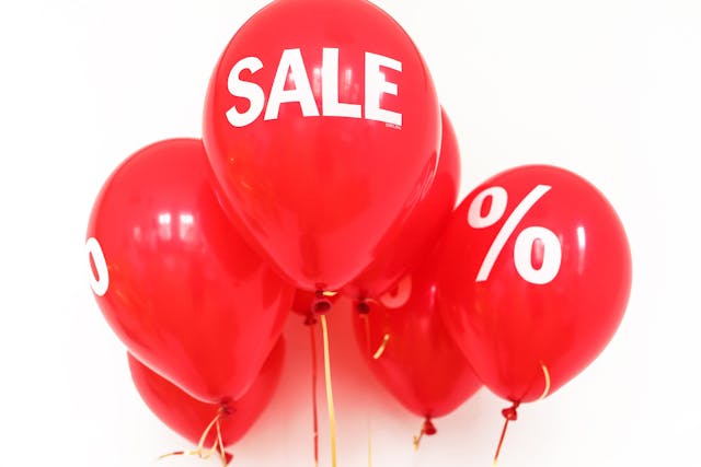 Red balloons that say "sale" and "%".