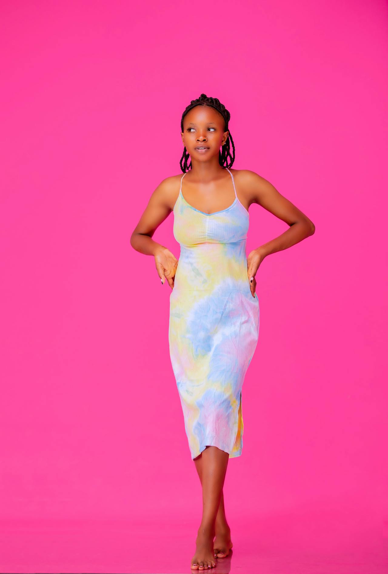 A model posing in front of a bright pink background.