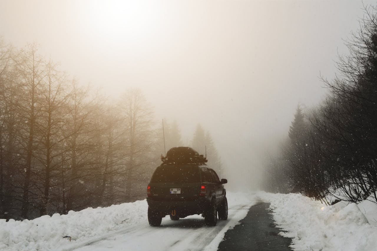 A car driving on a snow covered road.