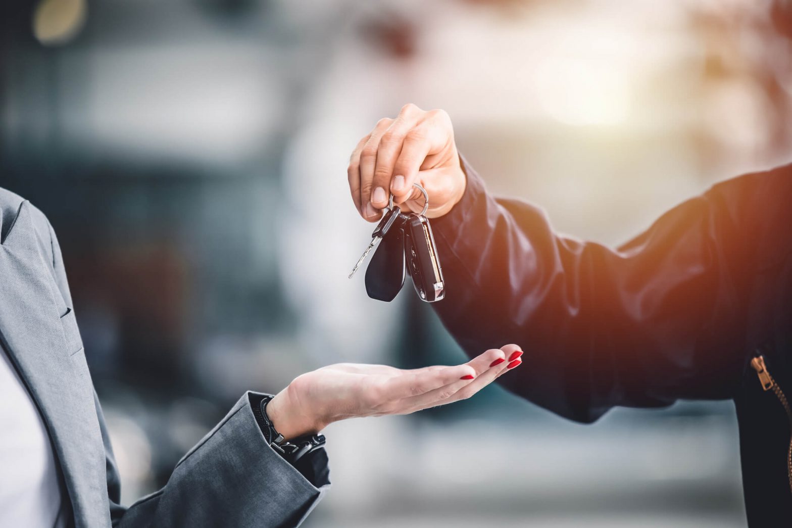 One person gives another person car keys.