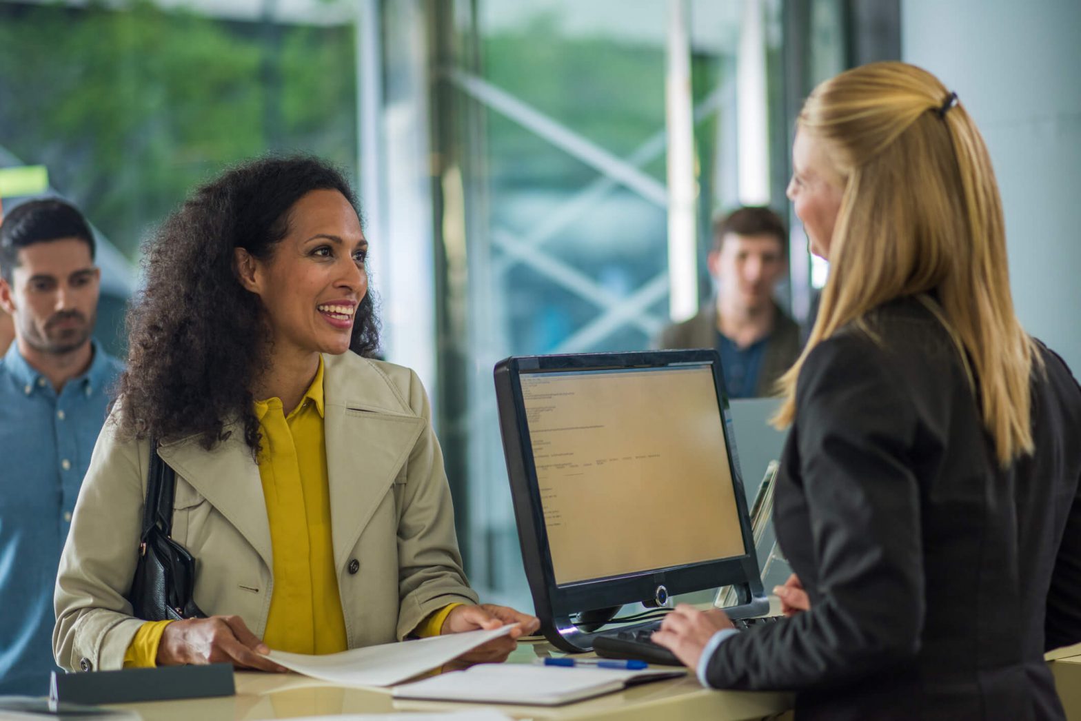A woman talks with a bank teller.